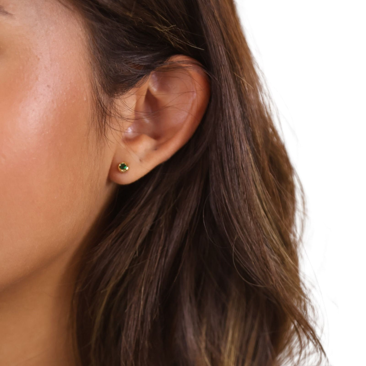 Woman wearing a birthstone round bezel stud earring in 18K gold-filled