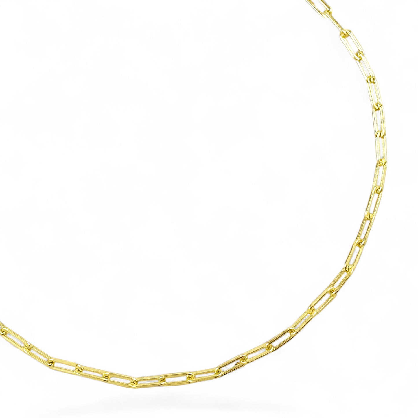 A close-up of a gold paperclip chain jbracelet on a clean white background.