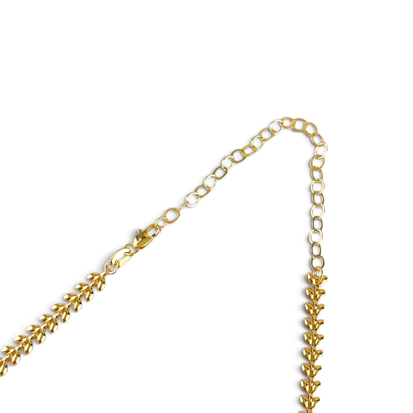 A close-up of a gold chain necklace with a leaf link