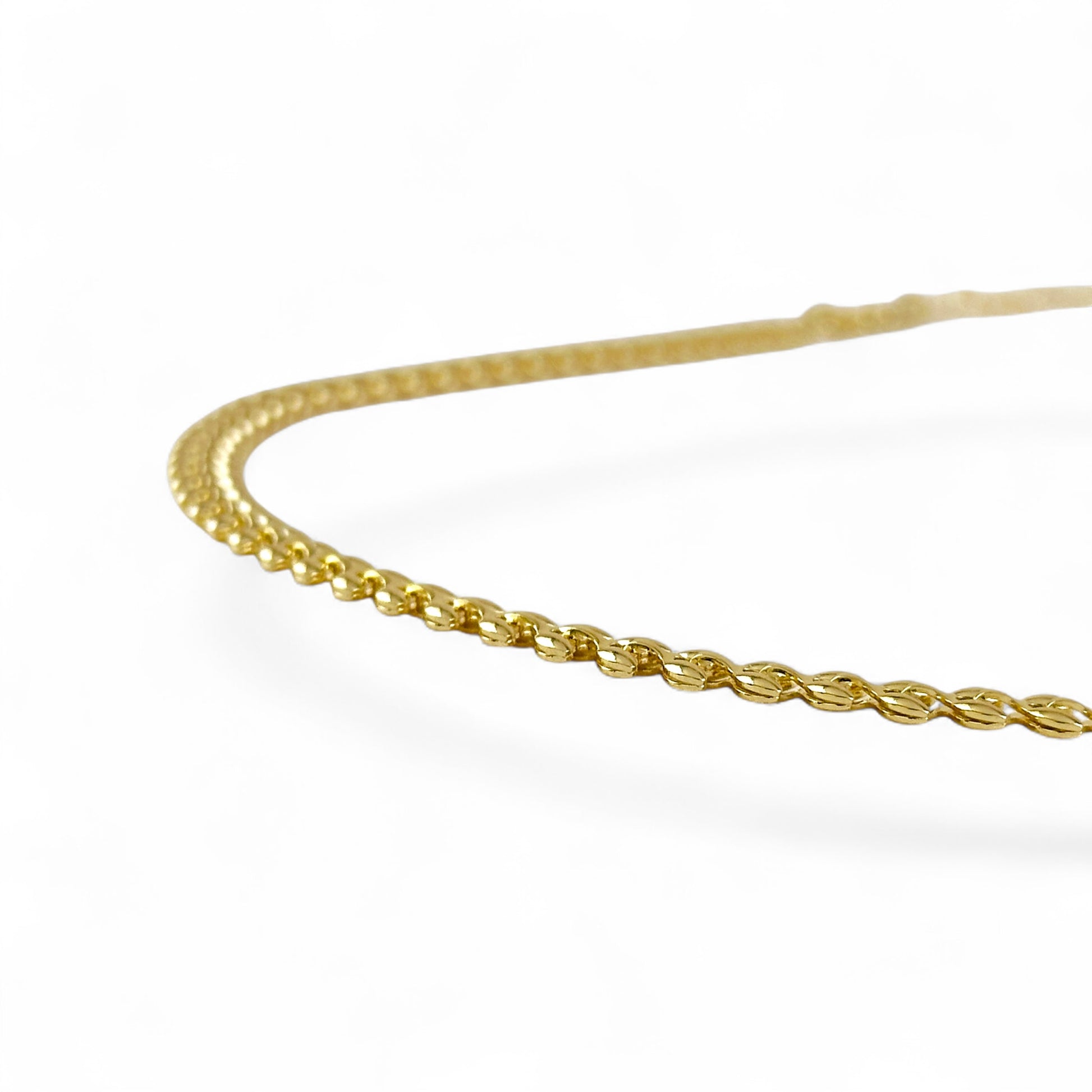 A close-up of a polished yellow gold chain,