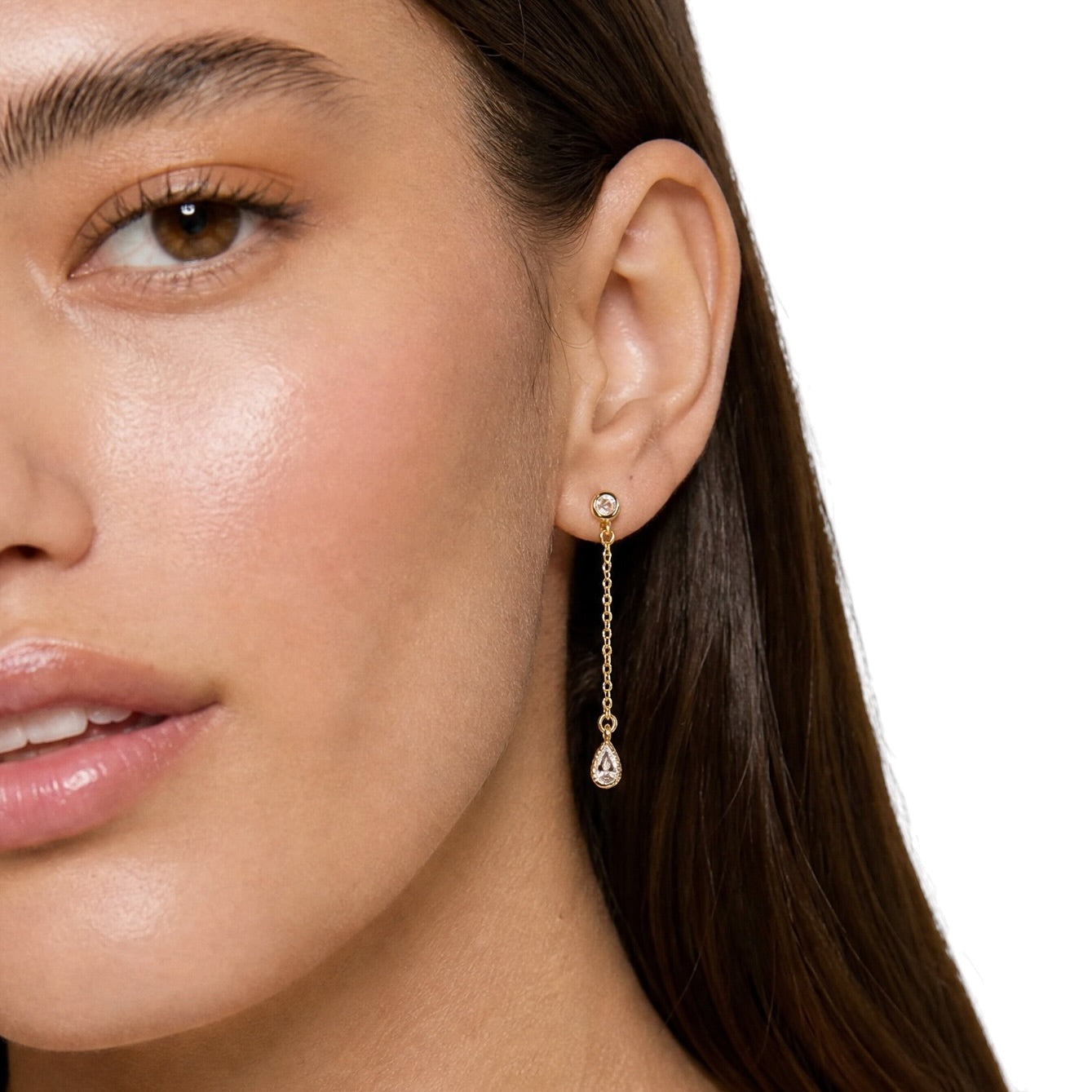 A close-up of a woman's ear with round CZ drop earring