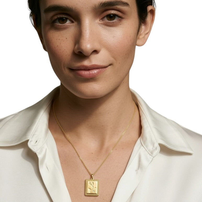 A close-up of a woman wearing a delicate gold chain necklace 