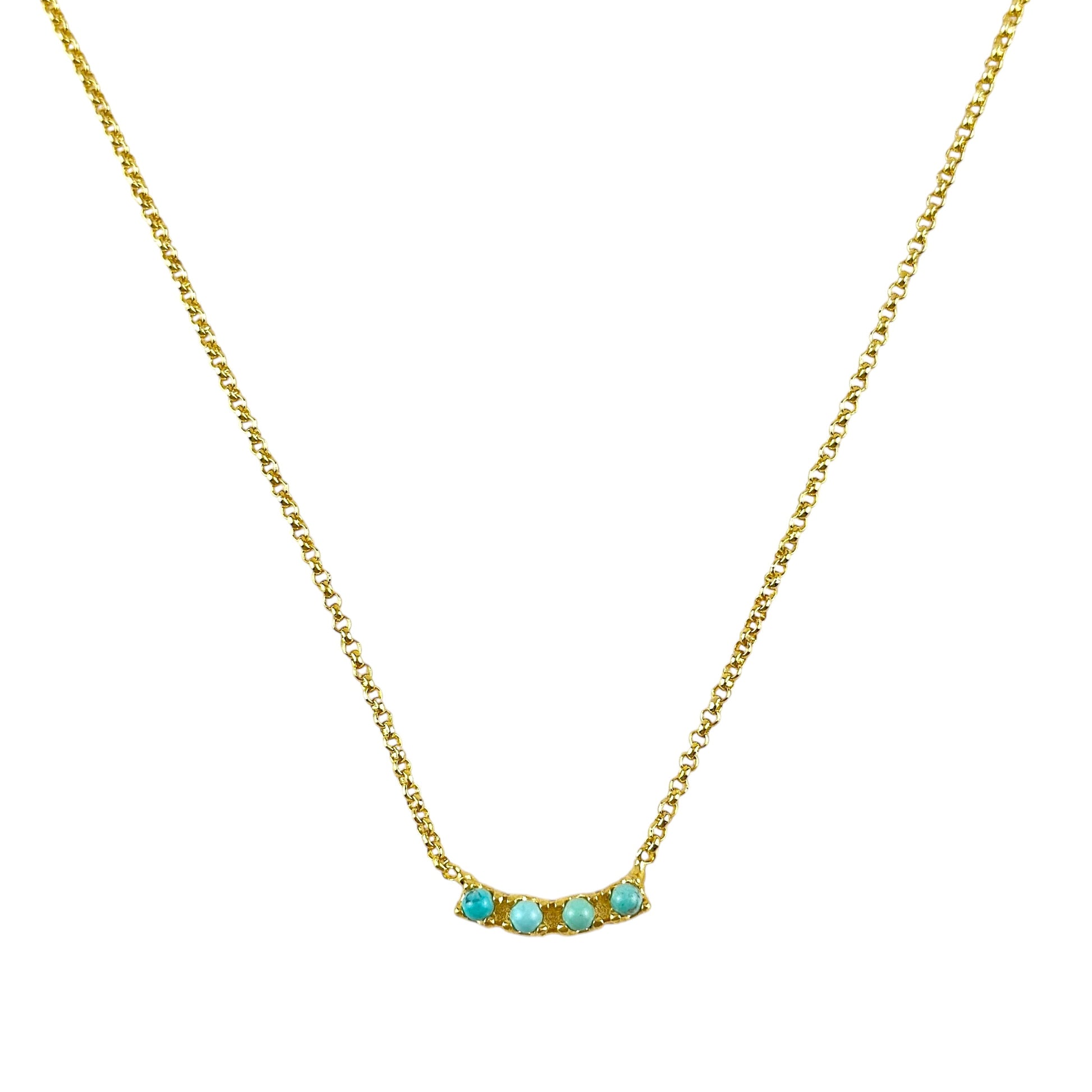 A delicate gold chain necklace featuring a small curved bar pendant with four small turquoise-colored stones, set against a plain white background.