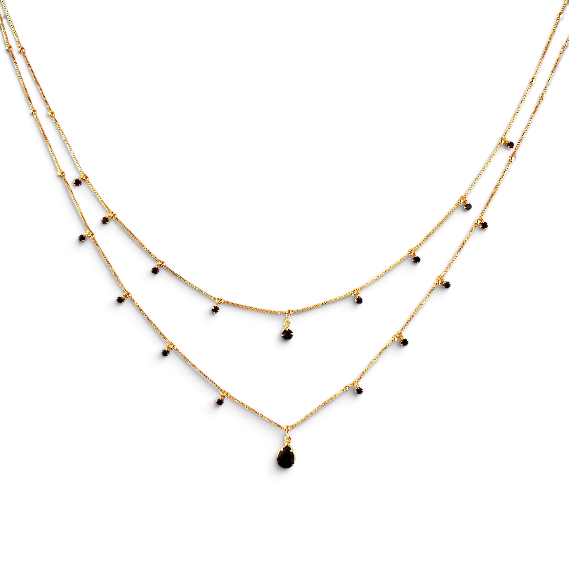 A double-layered gold necklace with small black bead accents and a teardrop-shaped black pendant