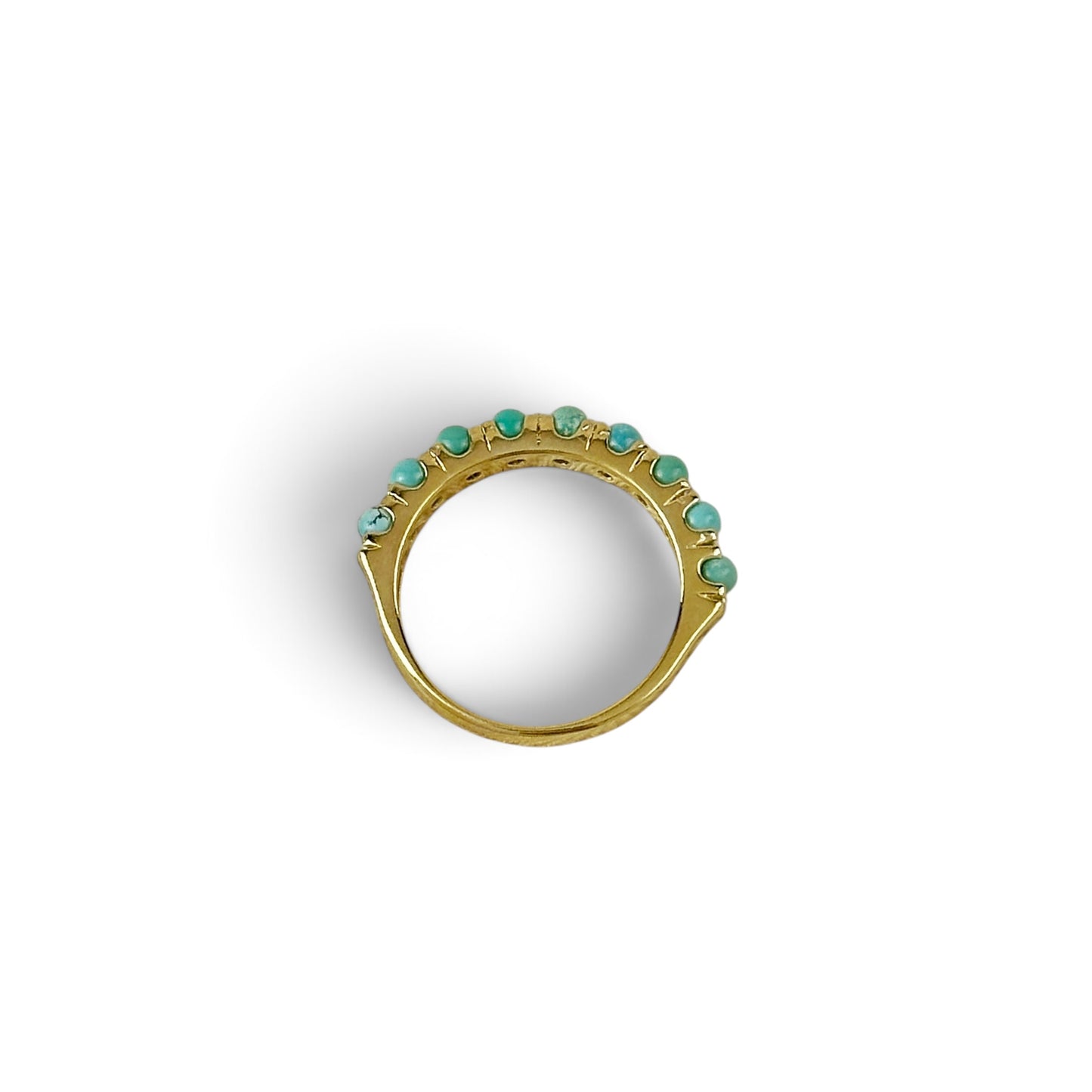 A gold ring featuring a row of small turquoise-colored gemstones set along the top, photographed on a clean white background.