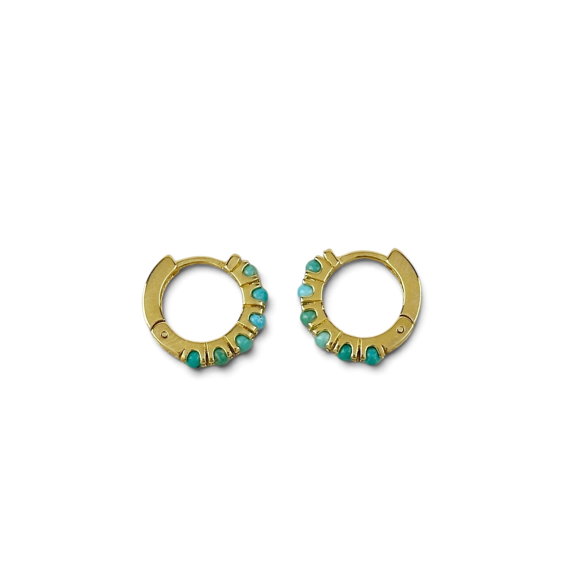 A pair of gold huggie hoop earrings decorated with small turquoise-colored stones, shown against a plain white background.