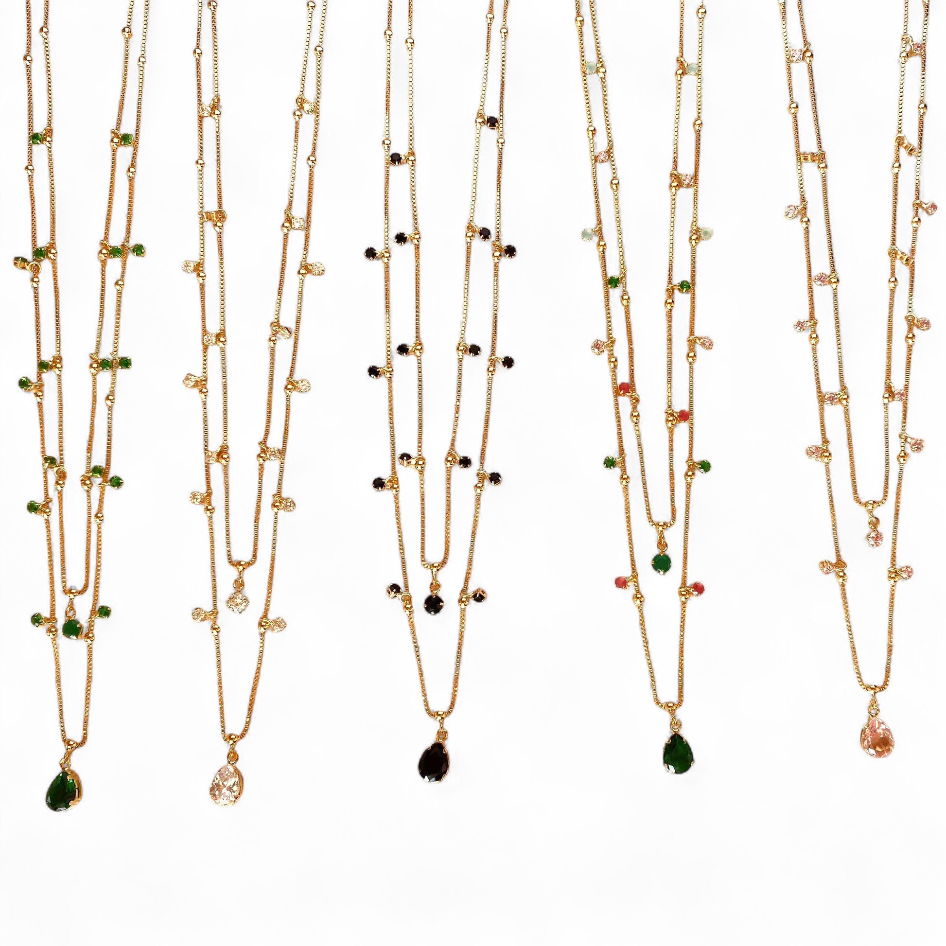 Five gold-toned multi-strand necklaces with small bead accents and teardrop-shaped gemstone pendant