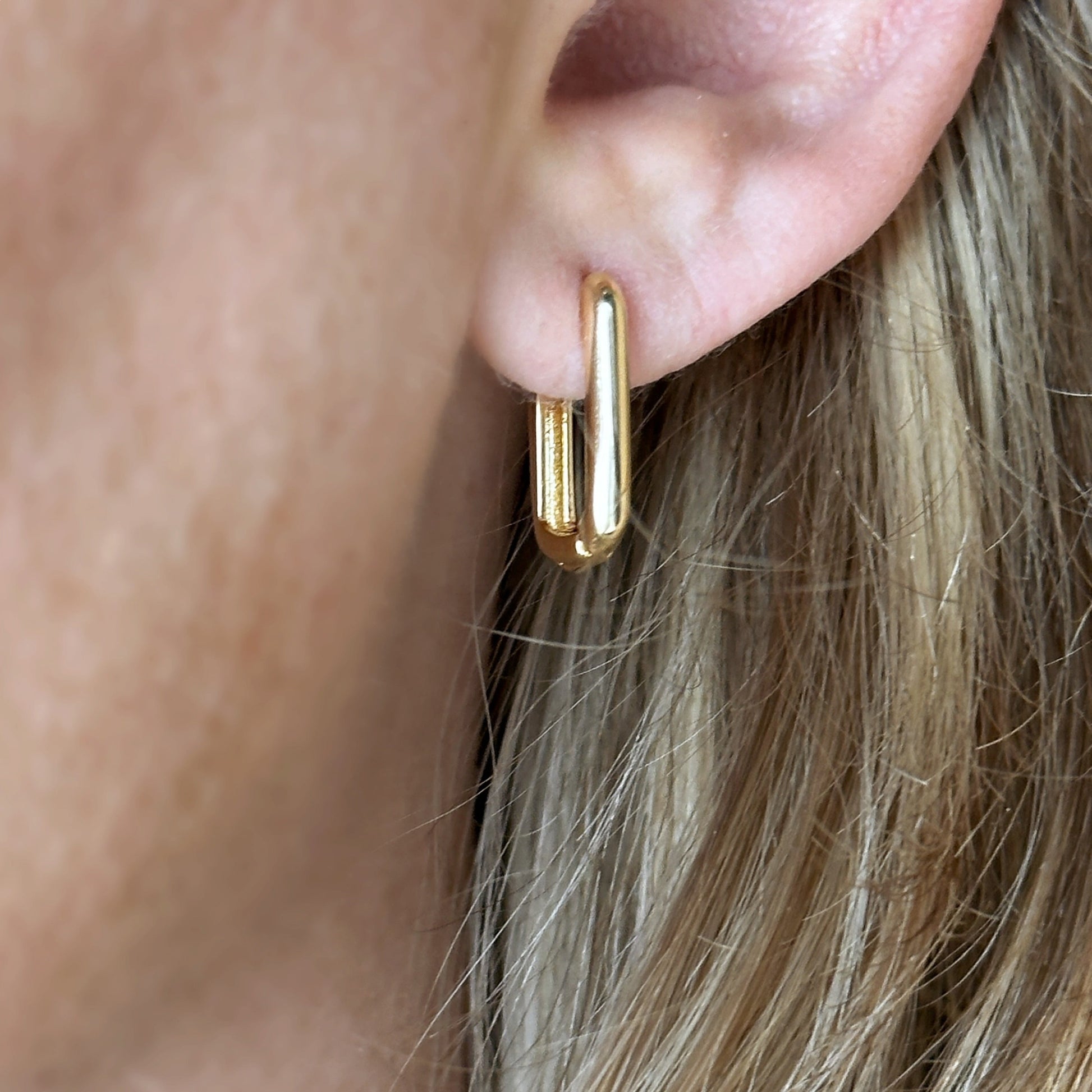 Woman wearing Oblong Huggie Hoop Earrings
