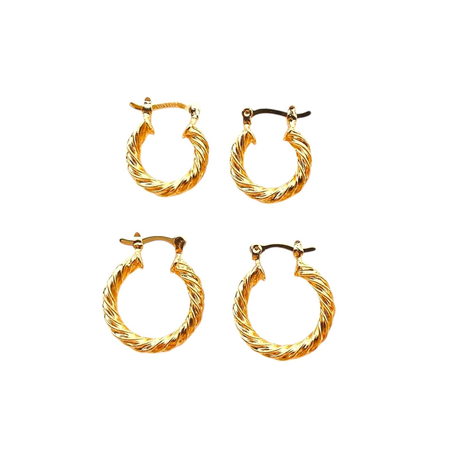 Set of four gold hoop earrings on a white background