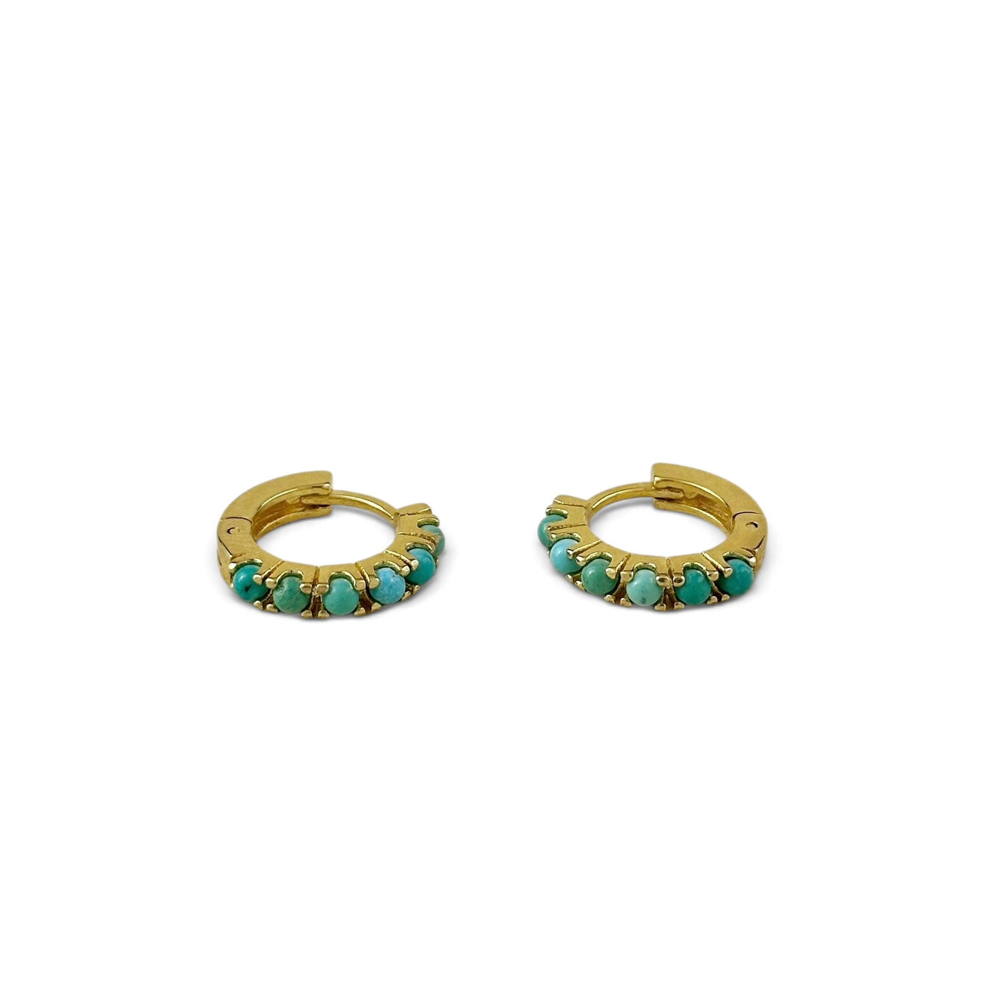 A pair of gold huggie hoop earrings embellished with small round turquoise-blue stones, displayed on a clean white background.