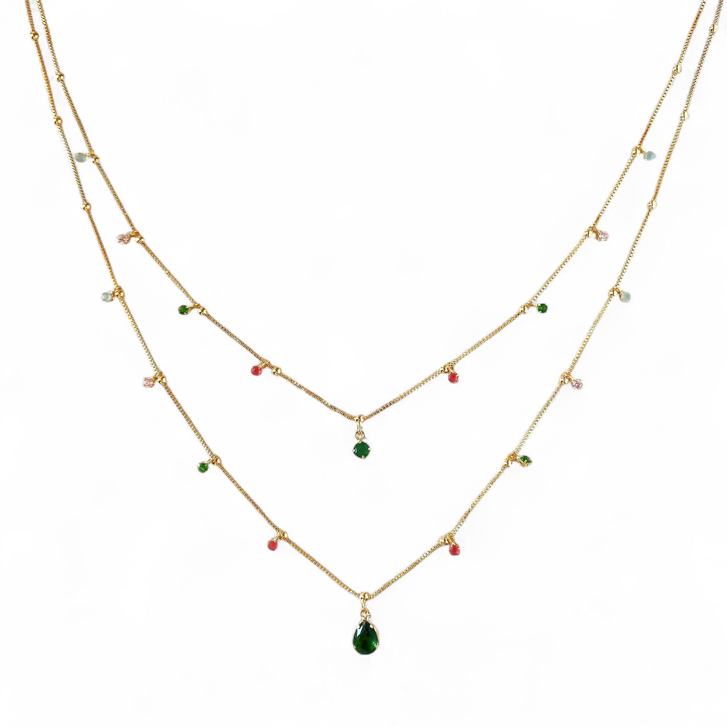 A double-layered gold necklace with small colorful gemstone beads and a teardrop-shaped green pendant, displayed on a solid white background.